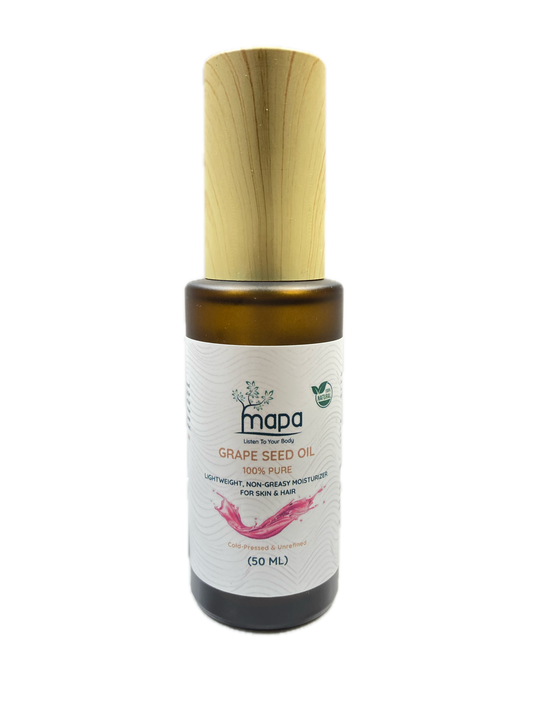 Bottle of Mada Grapeseed Oil with a wooden applicator on a white background